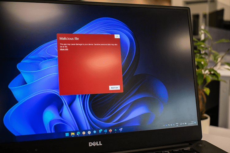 Image of laptop screen with red popup that says "Malicious file" on it